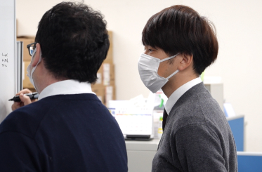 仲間と立ちながらミーティング中の様子